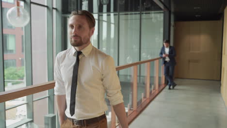 A-young-businessman-walking-through-the-corridors-of-the-airport-carrying-a-trolley-during-a-business-trip