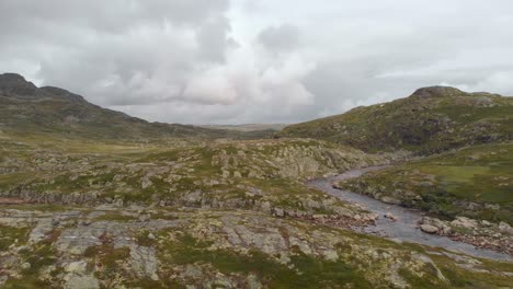 rocky green norway hardangervidda valley and river, aerial side truck view