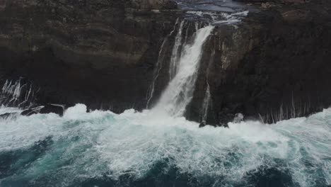 aerial backwards shot of bösdalafossur waterfall near leitisvatn lake on vagar, faroe islands - panorama view of nature