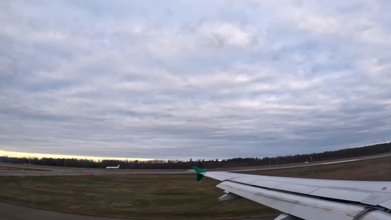 A calm view from the plane window as it slowly rolls across the airport field before takeoff or after landing.
