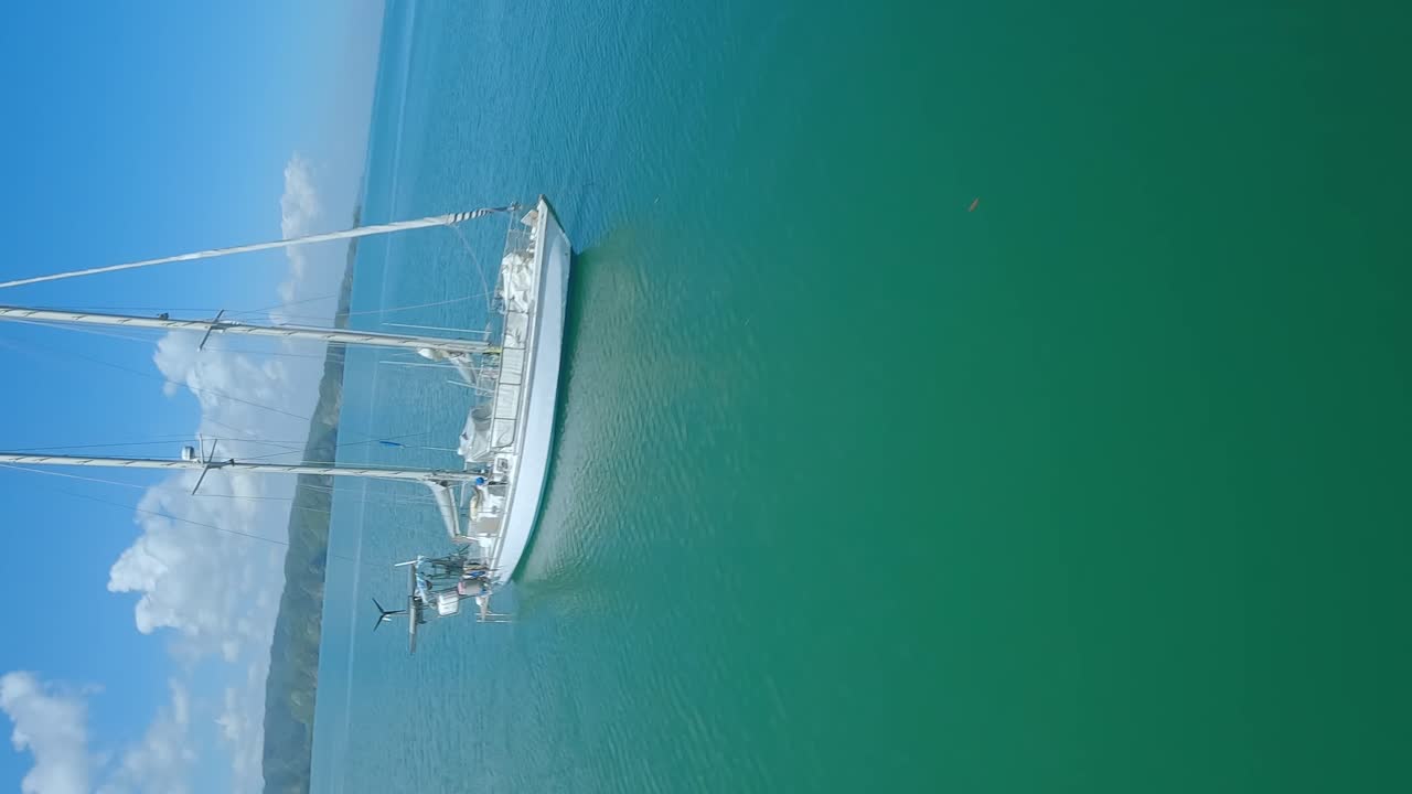 vuelo vertical de aviones no tripulados sobre la playa de los haitises con un velero anclado en la república dominicana - hermoso paisaje tropical durante un día soleado