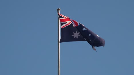 flag of australia swaying on the wind with blue sky on the background