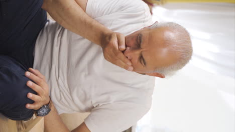 vertical video of the sick old man can't stop coughing.