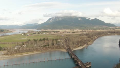 Vista-Aérea-De-Un-Río-En-El-Valle-Rodeado-Por-Un-Paisaje-Montañoso-Canadiense