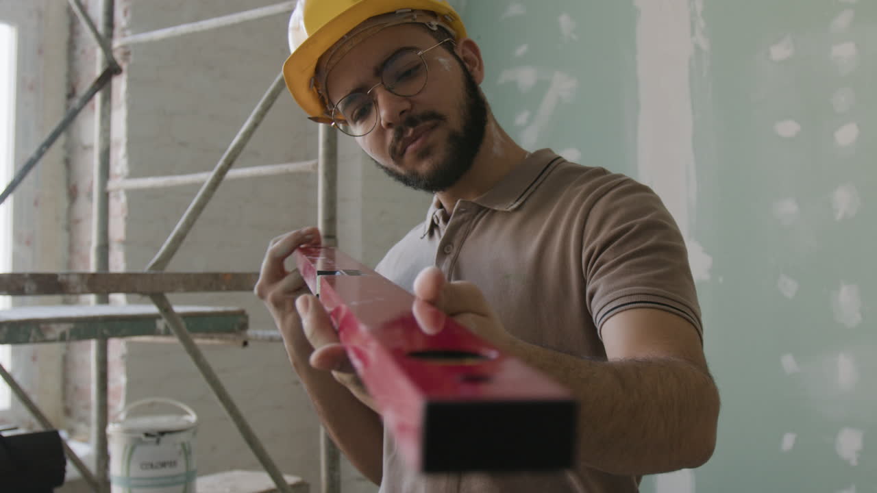 Construction worker using a level
