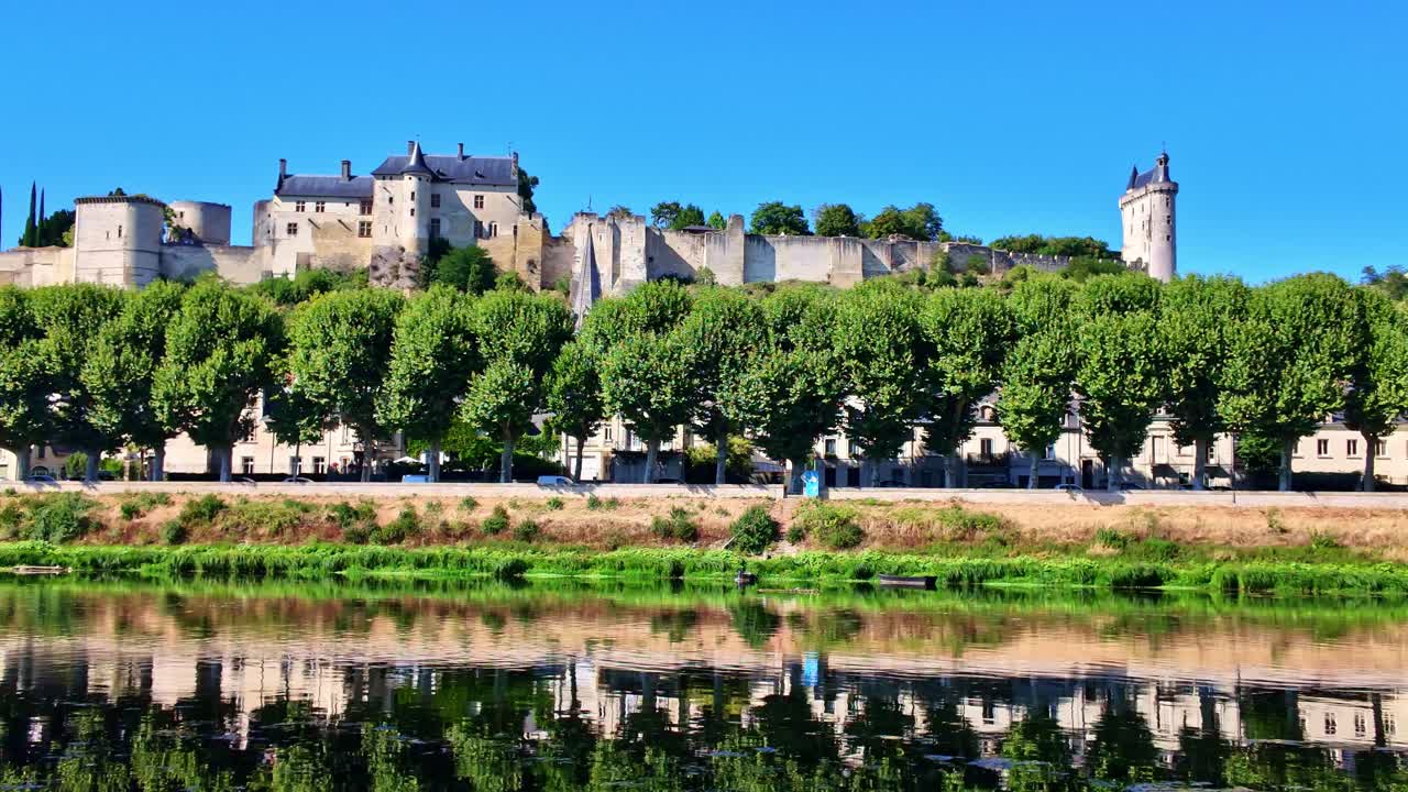 Royal Fortress of Chinon, medieval castle on hill reflected in Vienne River, Loire Valley, France. Panning