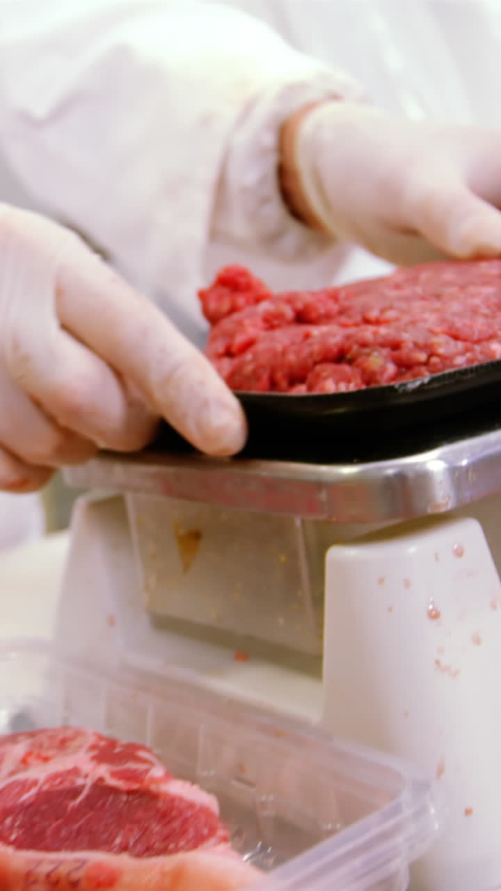 macellaio che controlla il peso della carne