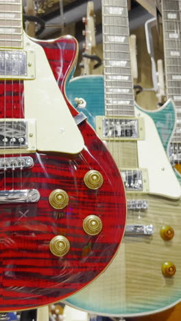 many electronic bass guitars hang on the wall in the shop.