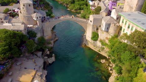 Revealing-Shot-Of-Stari-Most-With-People-Crossing-In-Mostar,-Bosnia-and-Herzegovina