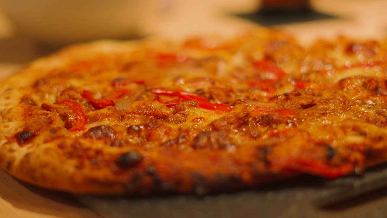 Side View of BBQ Chicken Pizza with Peppers on Table Ready to be Sliced into Pieces and Eaten by Family or Served to Customers.