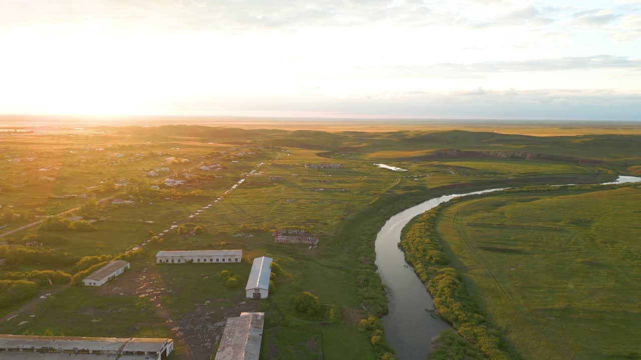 Aerial view of a winding river and rural landscape at sunset