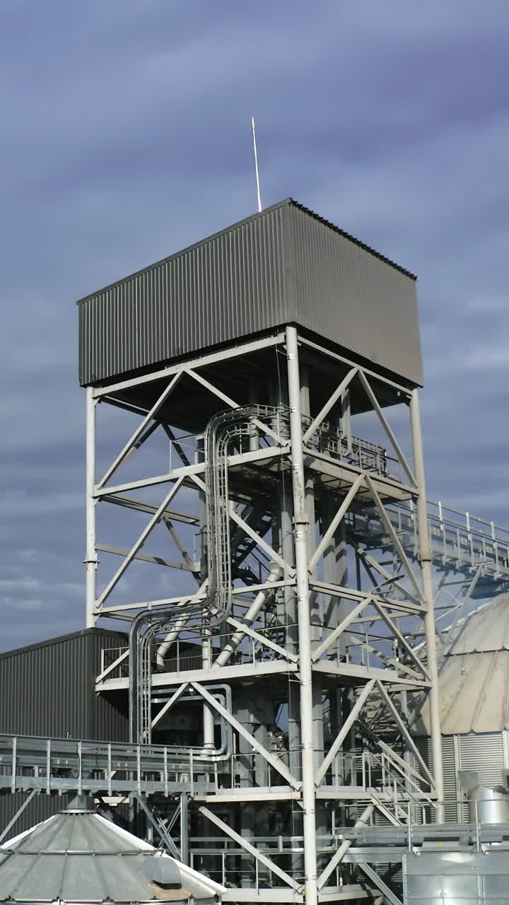 Grain farming harvesting silos. Elevator tanks factory aerial view. Vertical video