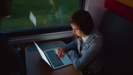 mujer usando una computadora portátil en un tren en movimiento