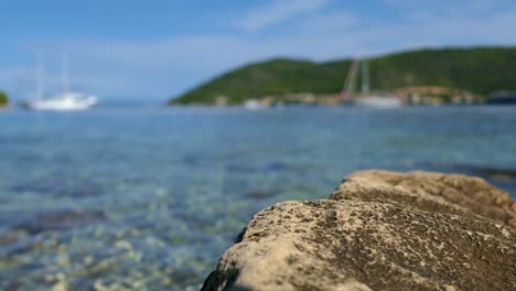 Mediterranean-sea-view-close-up,-seaside-town-detail,-sail-boats-in-background