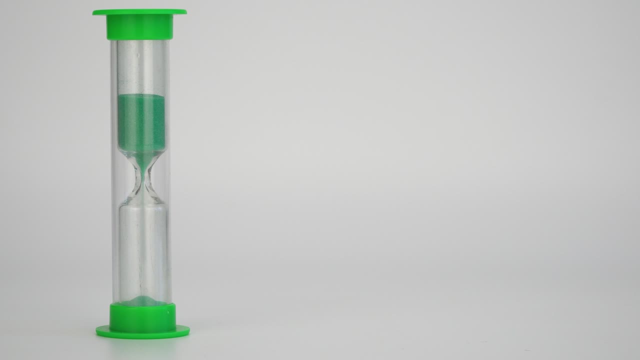 medical hourglass. sand measures the time. green sand pours down