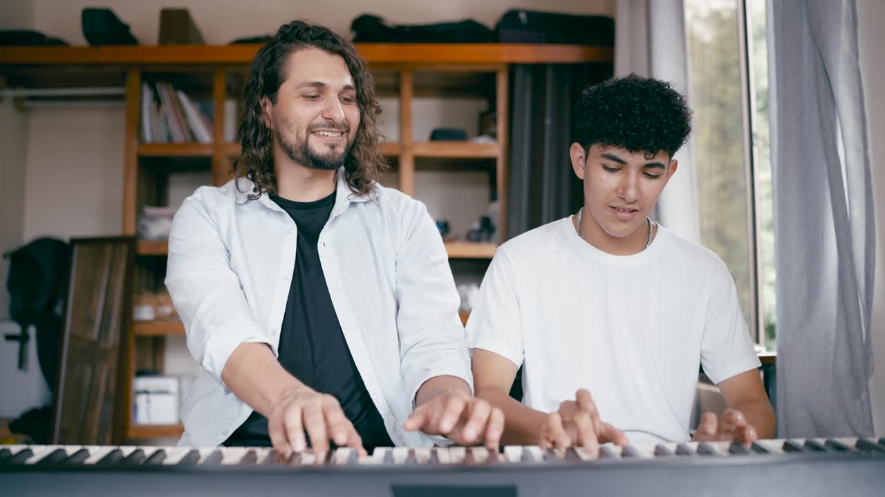 dos personas tocando el piano