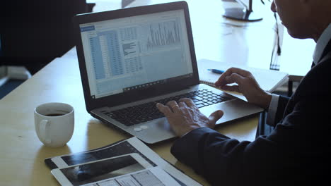 experto en finanzas maduro que usa una computadora portátil en el lugar de trabajo