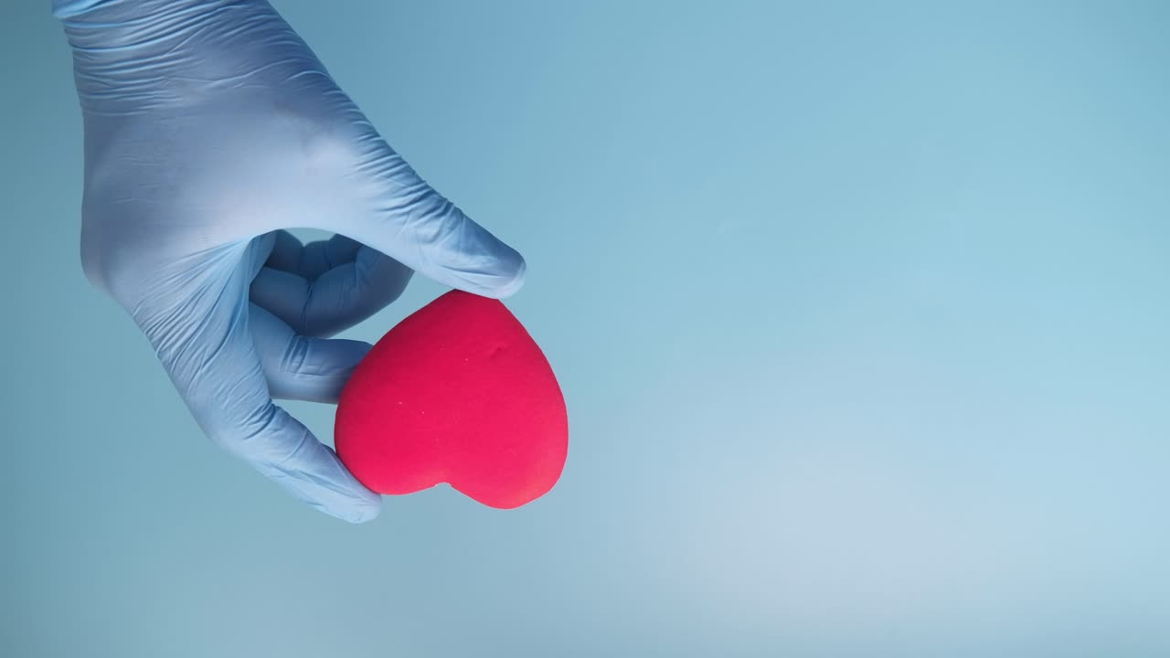 en el guante sosteniendo un corazón rosado