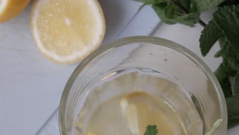 refreshing lemonade with ice, lemon slice and mint, seen from above on sunny day