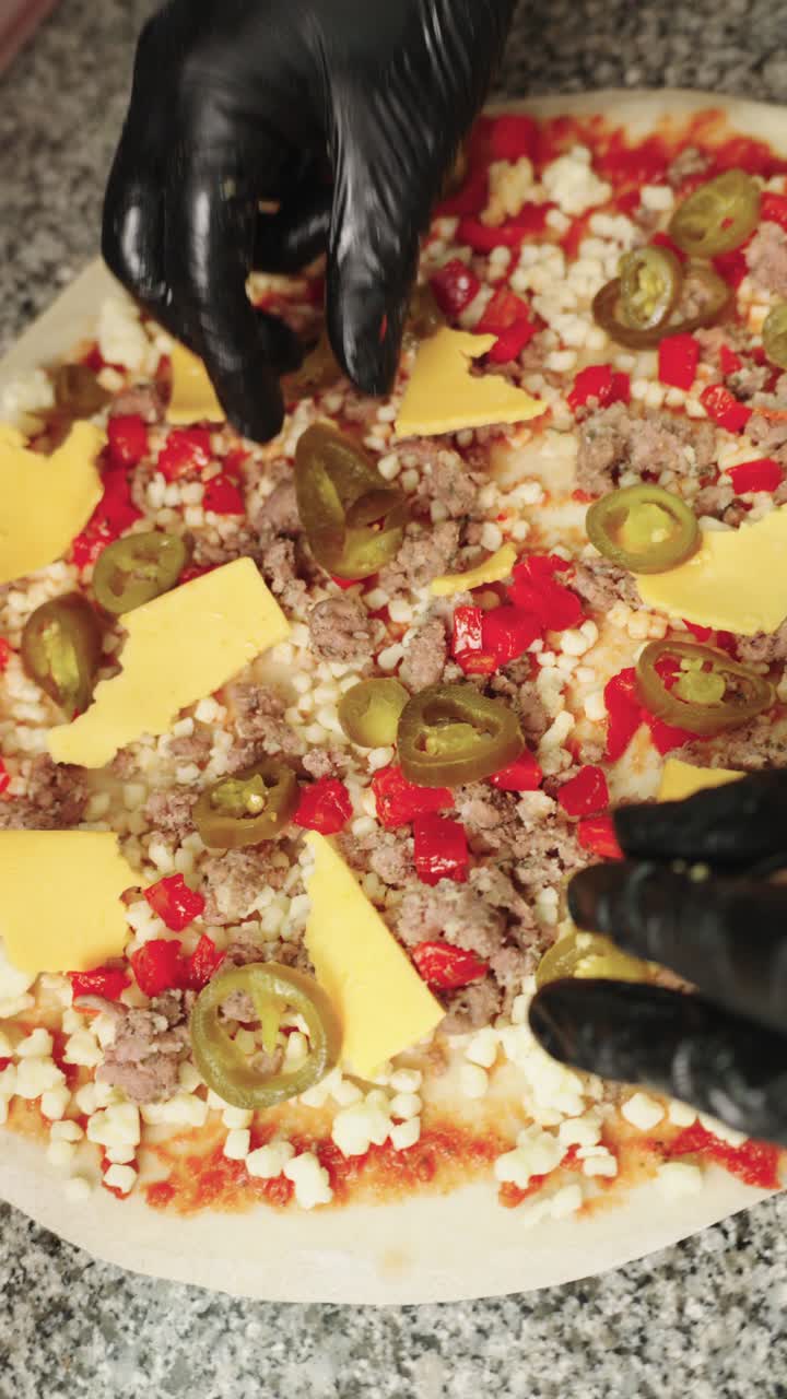 Preparing a Pizza with Cheese, Jalapenos, and Ground Meat