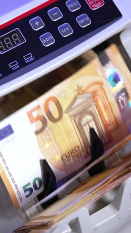 financial money currency counting machine. close up of euro banknotes while counting. vertical video