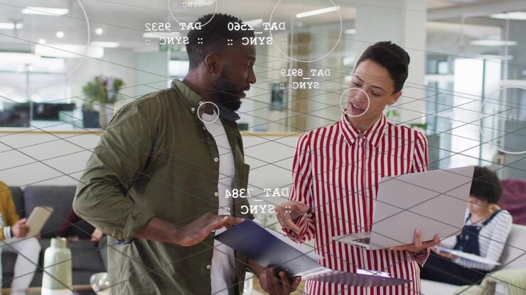 Man and woman reviewing folder and laptop during business review touching screen showing AR charts