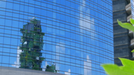 Reflection-inside-a-modern-building,-showing-Bosco-Verticale-in-Milan