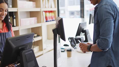 Video-De-Un-Hombre-Birracial-Feliz-Pagando-Con-Un-Teléfono-Inteligente-Un-Café-A-Una-Camarera-Birracial