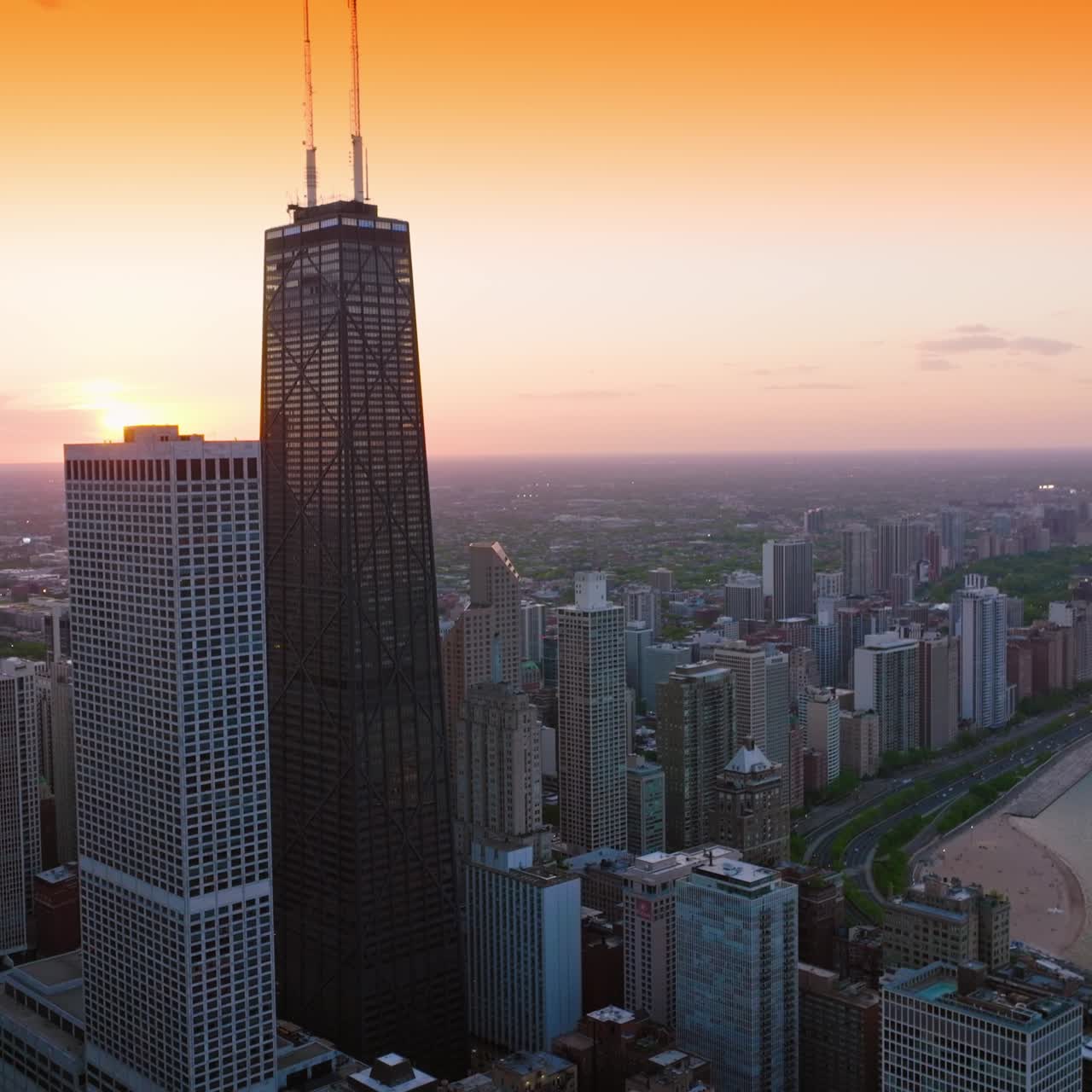 Flight over the waterfront built up with wonderful architecture. Chicago skyscrapers at the backdrop of orange sky