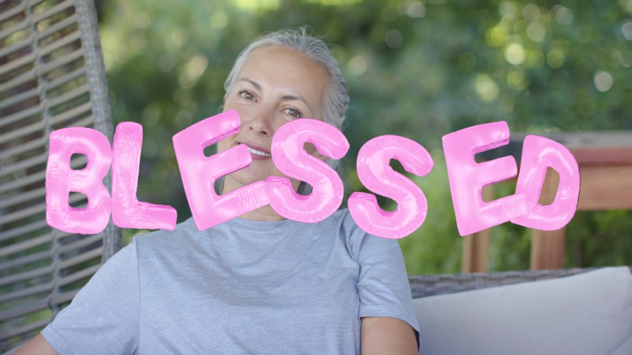 Femme tournant la tête, révélant un sourire, au-dessus d'un ballon rose "BLESSED" qui vacille au-dessus du cadre, pour un style de vie.
