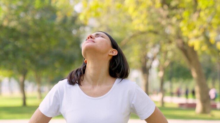 mujer india haciendo estiramiento de cuello en un parque por la mañana