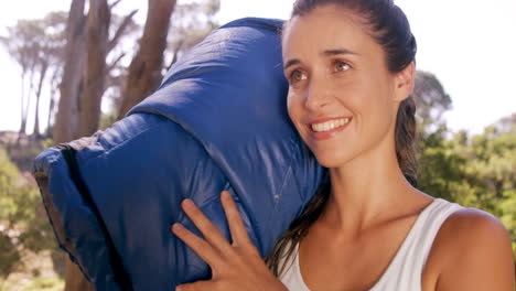 mujer sosteniendo una bolsa de dormir fuera de la tienda