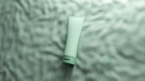 mint green cosmetic tube on a fabric surface