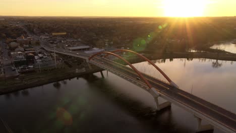 Vista-Aérea-En-órbita-Del-Puente-Hastings-Sobre-El-Río-Mississippi,-Mientras-El-Sol-Golpea-El-Horizonte-Distante