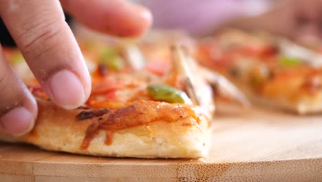 close-up shot of a person eating a delicious pizza