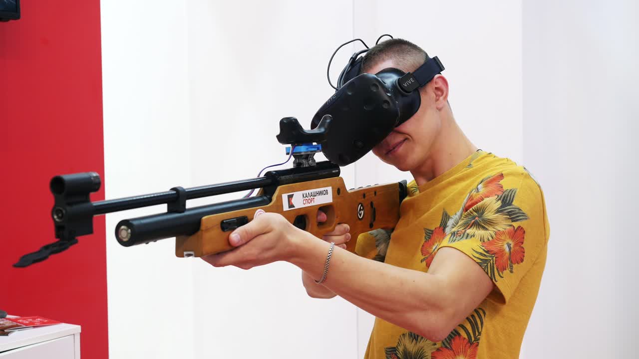 Man using VR headset and shooting VR Airsoft gun