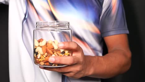 Man Holding a Jar of Mixed Nuts