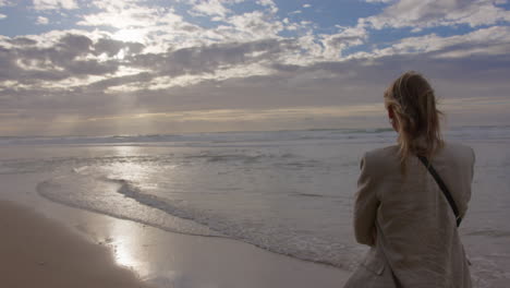 woman contemplating the ocean at sunset