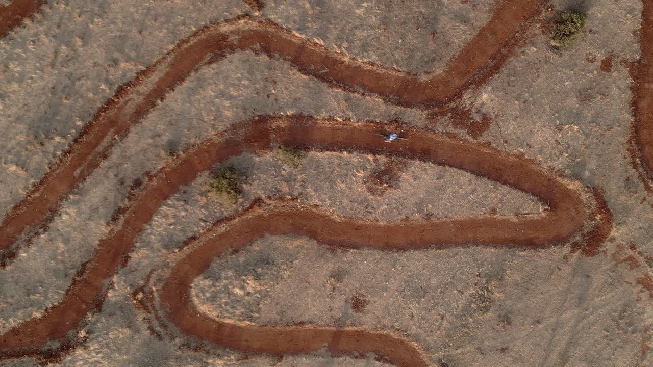 Mountain bike. Raider on circuit of mountain bike. Aerial view in descend. MTB. Driving bicycles at high speed on a circuit with sharp curves. MTB circuit at sunset. Granada. Spain.