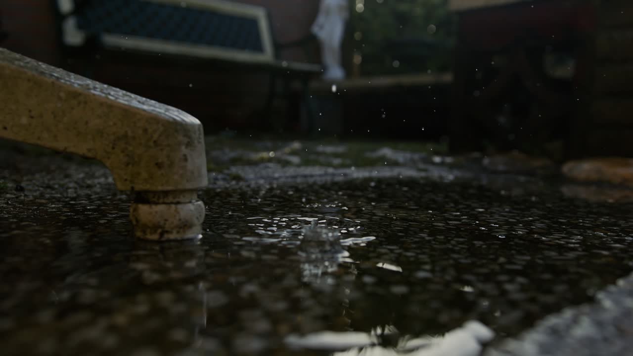A close-up of water splashing as rain falls onto the ground in Middelburg, Netherlands, super slow motion