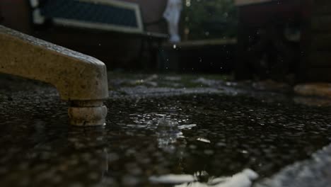 a close-up of water splashing as rain falls onto the ground in middelburg, netherlands, super slow motion