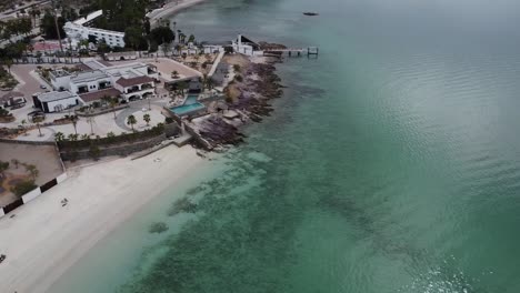 Stunning-aerial-view-von-Playa-El-Caymancito-Beach-Near-La-Paz,-Baja-California-Sur,-Mexico:-Turquoise-Sea,-Picturesque-Buildings,-Idyllic-Vacation-Scenery