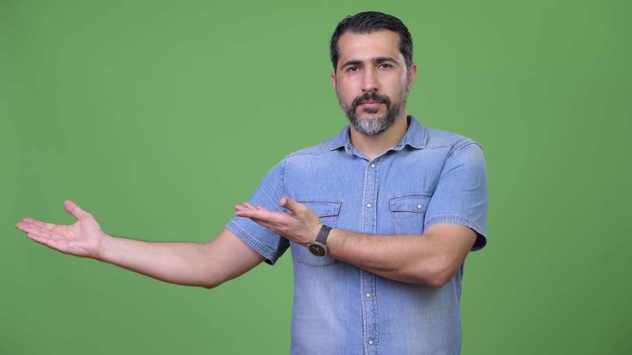 Handsome Persian bearded man showing something