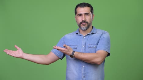 handsome persian bearded man showing something