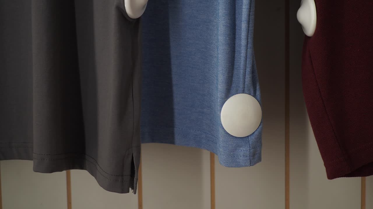 옷 가게의 랙에 매달린 세 개의 셔츠의 클로즈업