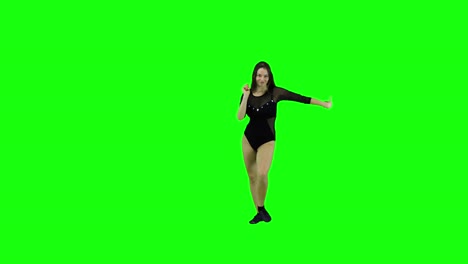 attractive and energetic female dancer dancing in front of a green screen