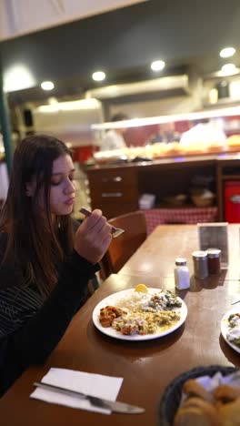 young woman eating turkish food in a restaurant