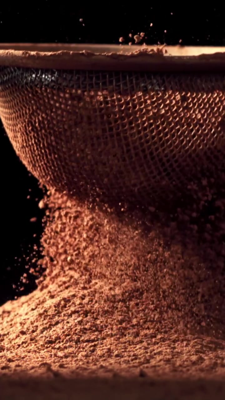 Fine Cocoa Powder Falling Through a Sieve in Slow Motion