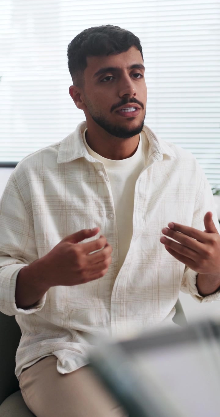 Young Man Talking and Gesturing During a Professional Meeting