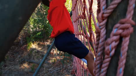 niño bajando por la red durante una carrera de obstáculos